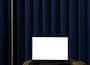 netbook on pouf near curtain in room
